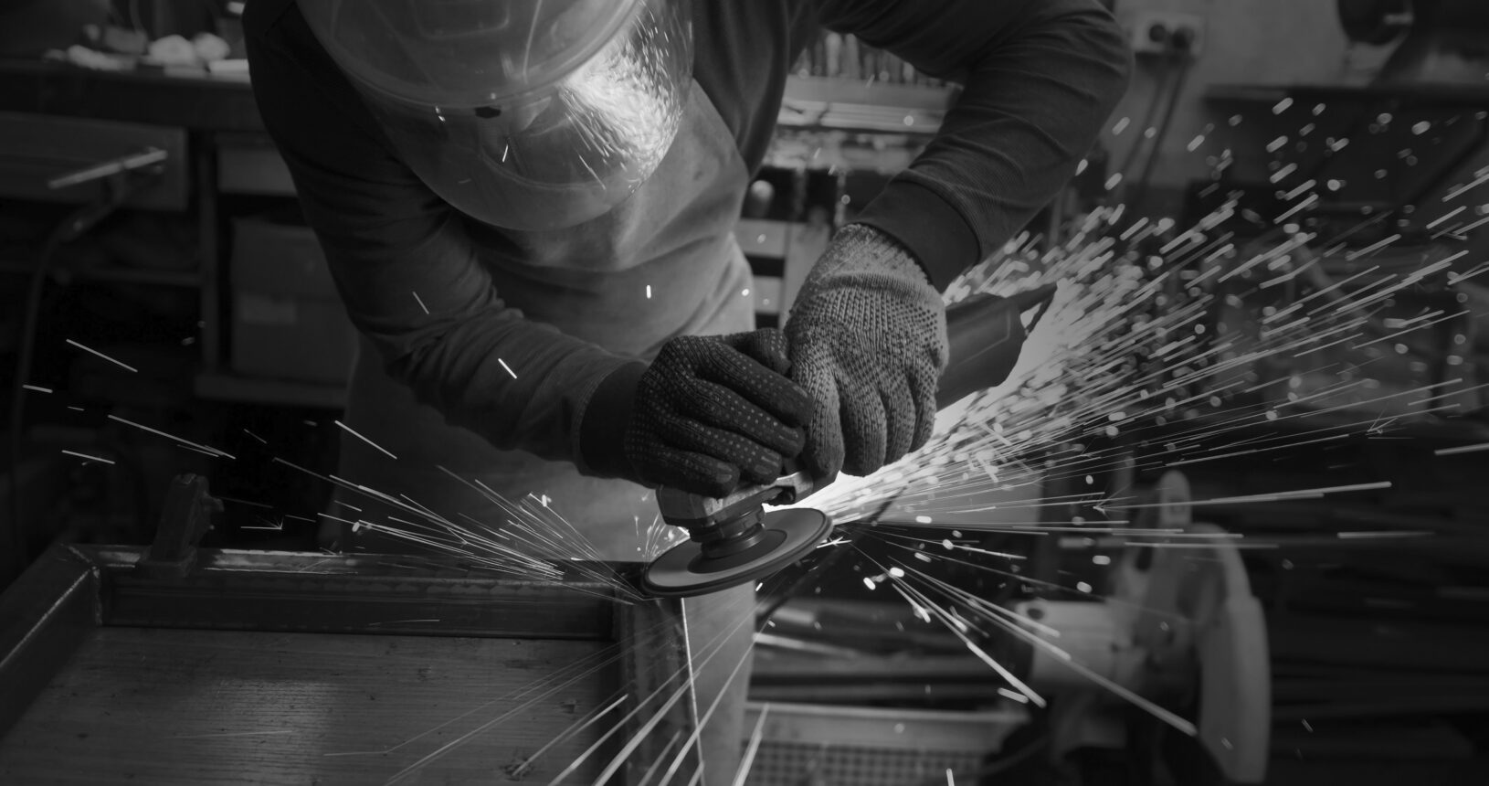 A man in gloves cuts metal with a circular saw, a lot of sparks. The working process