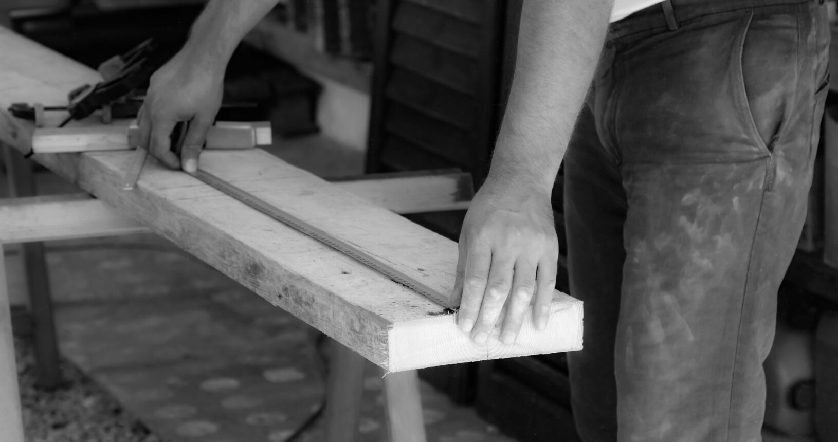 Male carpenter working with wood material in a garage.